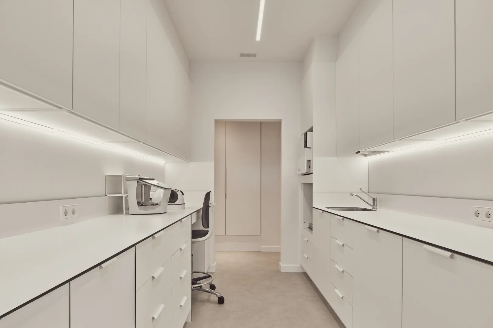 Sala de esterilización con encimeras y armarios blancos